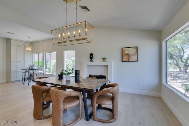9520 Sundial Dr, Las Vegas, NV 89134 - dining room featuring healthy amount of natural light, light wood-type flooring, a brick fireplace, and a chandelier