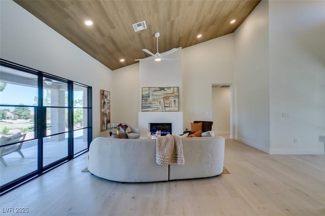 9520 Sundial Dr, Las Vegas, NV 89134 - living room featuring healthy amount of natural light, a glass covered fireplace, high vaulted ceiling, light wood-style flooring, and recessed lighting