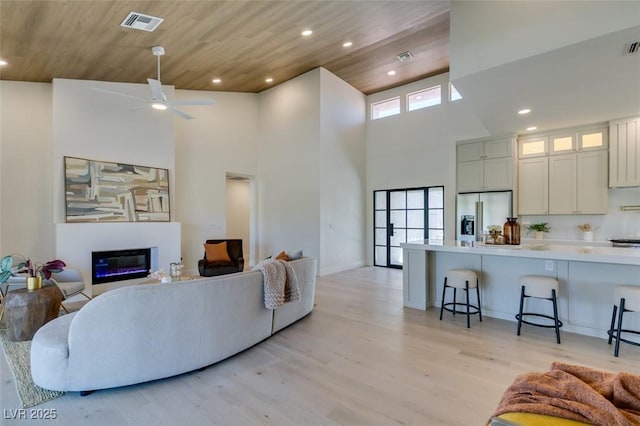 9520 Sundial Dr, Las Vegas, NV 89134 - living area with a glass covered fireplace, recessed lighting, light wood-style floors, a high ceiling, and a ceiling fan