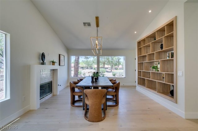 9520 Sundial Dr, Las Vegas, NV 89134 - dining room with vaulted ceiling, light wood-type flooring, a fireplace, and recessed lighting
