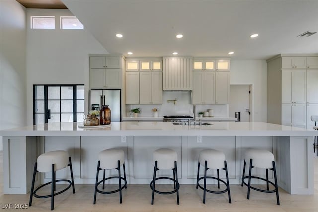 9520 Sundial Dr, Las Vegas, NV 89134 - kitchen featuring stainless steel refrigerator with ice dispenser, extractor fan, recessed lighting, a spacious island, and light countertops