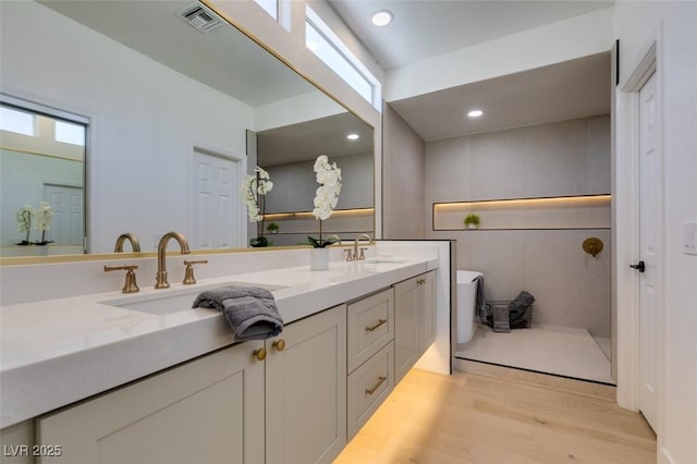 9520 Sundial Dr, Las Vegas, NV 89134 - bathroom with double vanity, wood finished floors, a freestanding bath, and recessed lighting
