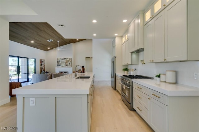 9520 Sundial Dr, Las Vegas, NV 89134 - kitchen with high quality appliances, light wood-type flooring, a ceiling fan, open floor plan, and a kitchen island with sink