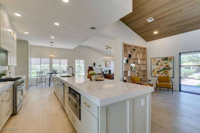 9520 Sundial Dr, Las Vegas, NV 89134 - kitchen with stainless steel appliances, recessed lighting, light wood-style floors, plenty of natural light, and lofted ceiling