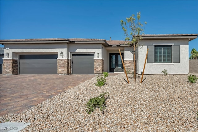 5851 Slate Rock Ct, Las Vegas, NV 89149 - prairie-style house featuring a garage, decorative driveway, french doors, stucco siding, and stone siding