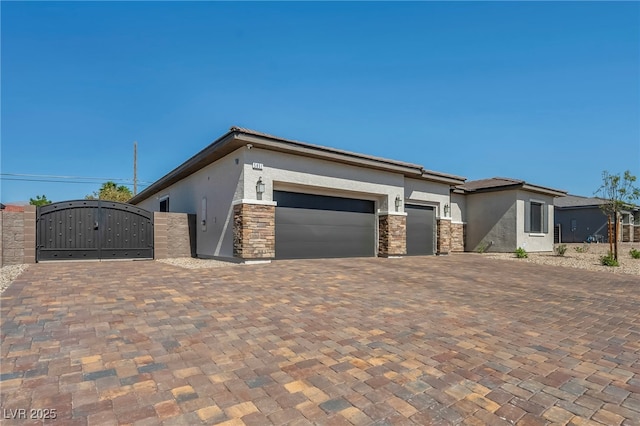 5851 Slate Rock Ct, Las Vegas, NV 89149 - view of front facade with a gate, stucco siding, an attached garage, and stone siding