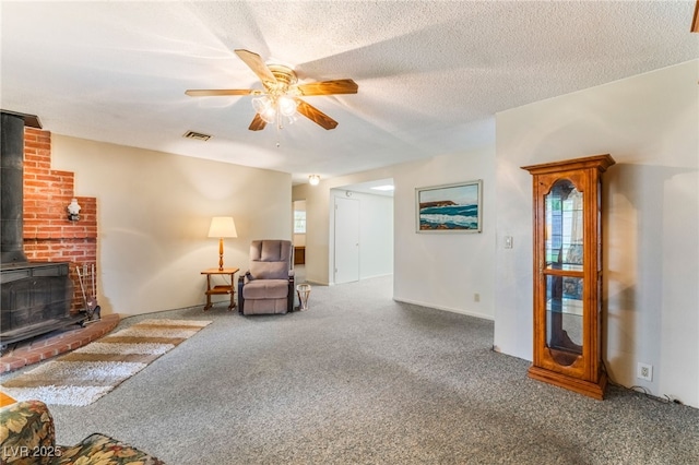 1904 Fontenelle St, Las Vegas, NV 89102 - living room featuring a wood stove, carpet floors, ceiling fan, and a textured ceiling