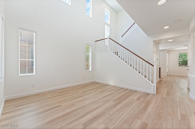 11900 Calle De Sol Dr, Las Vegas, NV 89138 - unfurnished living room with stairs, light wood-type flooring, recessed lighting, and a high ceiling