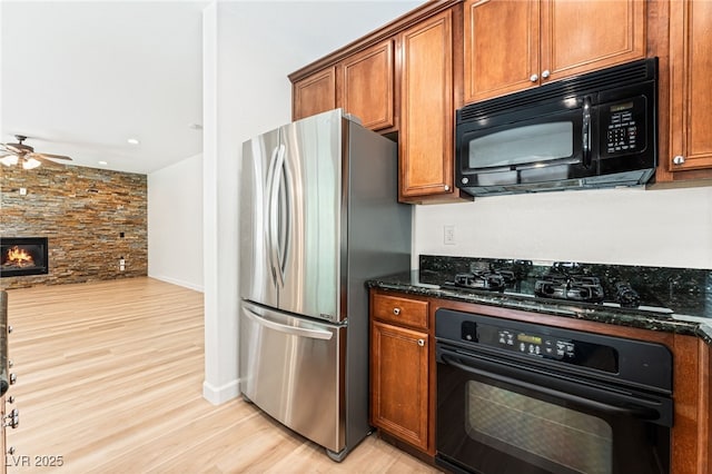 11900 Calle De Sol Dr, Las Vegas, NV 89138 - kitchen featuring black appliances, ceiling fan, dark stone countertops, brown cabinetry, and recessed lighting