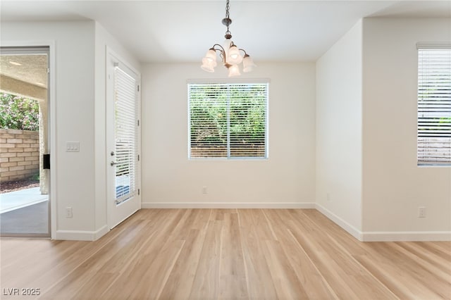 11900 Calle De Sol Dr, Las Vegas, NV 89138 - unfurnished dining area with a chandelier, light wood-style flooring, and healthy amount of natural light
