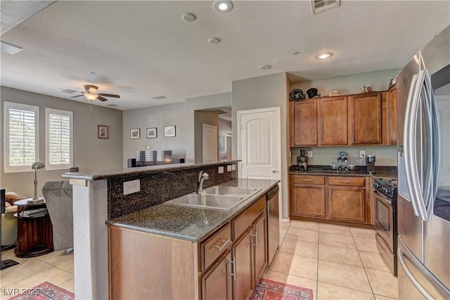 1904 Via Firenze, Henderson, NV 89044 - kitchen with stainless steel appliances, brown cabinetry, open floor plan, and ceiling fan