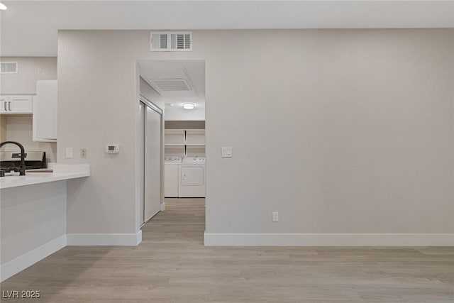 5751 E Hacienda Ave Unit 159, Las Vegas, NV 89122 - hallway featuring light wood-style floors and washing machine and clothes dryer