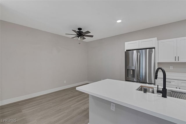 5751 E Hacienda Ave Unit 159, Las Vegas, NV 89122 - kitchen featuring stainless steel refrigerator with ice dispenser, ceiling fan, white cabinetry, light countertops, and light wood finished floors