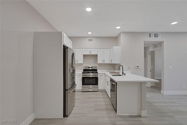 5751 E Hacienda Ave Unit 159, Las Vegas, NV 89122 - kitchen with stainless steel appliances, a peninsula, light countertops, white cabinetry, and light wood-type flooring