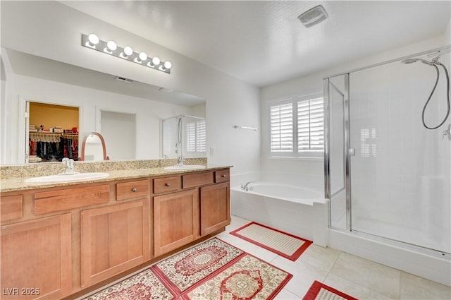 3949 Amanda Bay Ave, North Las Vegas, NV 89081 - bathroom featuring a shower stall, a garden tub, tile patterned floors, double vanity, and a walk in closet