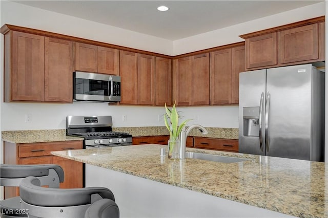 3949 Amanda Bay Ave, North Las Vegas, NV 89081 - kitchen featuring appliances with stainless steel finishes, recessed lighting, light stone counters, and brown cabinets