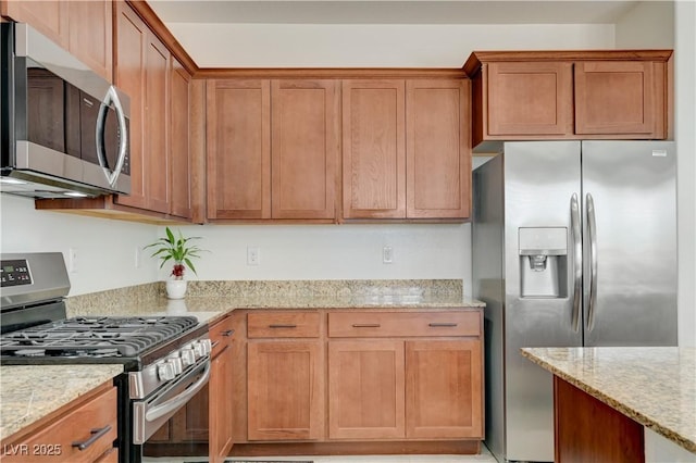 3949 Amanda Bay Ave, North Las Vegas, NV 89081 - kitchen featuring stainless steel appliances, light stone counters, and brown cabinets