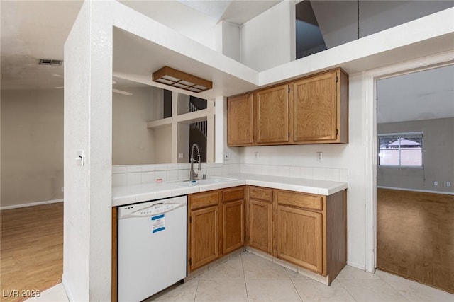 426 Lost Trail Dr, Henderson, NV 89014 - kitchen with dishwasher, brown cabinetry, and tile countertops