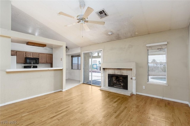 426 Lost Trail Dr, Henderson, NV 89014 - unfurnished living room featuring light wood finished floors, a fireplace, ceiling fan, and vaulted ceiling