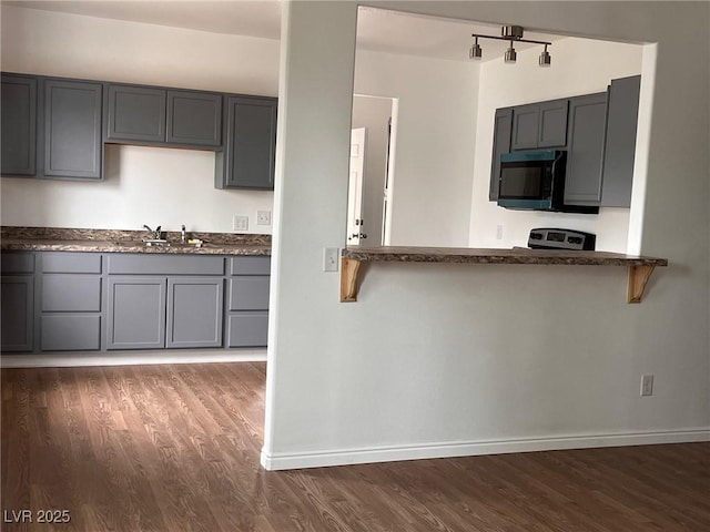 49 Fourth, Mcgill, NV 89318 - kitchen featuring black microwave, dark wood finished floors, gray cabinetry, and a breakfast bar area