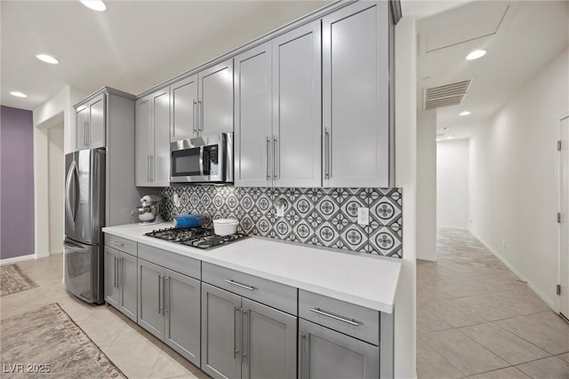 605 Cadence Vista Dr, Henderson, NV 89011 - kitchen featuring stainless steel appliances, gray cabinets, tasteful backsplash, light countertops, and light tile patterned floors