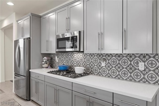 605 Cadence Vista Dr, Henderson, NV 89011 - kitchen with stainless steel appliances, gray cabinetry, decorative backsplash, light countertops, and recessed lighting