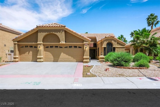 2216 Sapphire Valley St, Las Vegas, NV 89128 - mediterranean / spanish-style house featuring an attached garage, stucco siding, concrete driveway, and a tiled roof