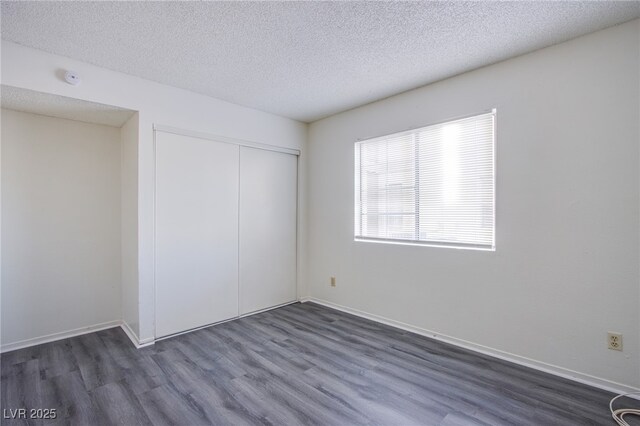 2696 Jennydiane Dr, Las Vegas, NV 89121 - unfurnished bedroom with dark wood-style floors, a closet, and a textured ceiling