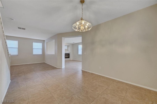 189 Paxon Hollow Ct, Las Vegas, NV 89148 - unfurnished room with a chandelier and a glass covered fireplace