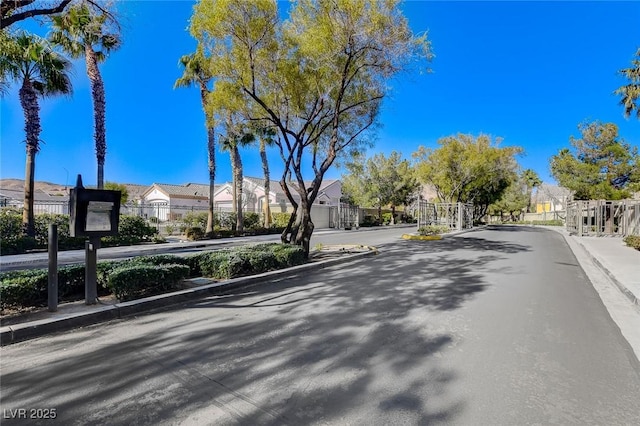 189 Paxon Hollow Ct, Las Vegas, NV 89148 - view of asphalt road featuring a residential view, a gate, curbs, and sidewalks
