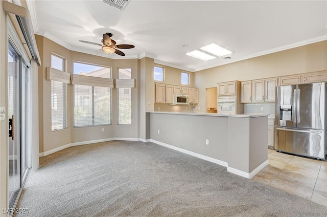 1904 Hot Oak Ridge St, Las Vegas, NV 89134 - kitchen featuring white appliances, light colored carpet, crown molding, a ceiling fan, and light countertops
