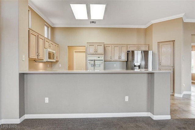 1904 Hot Oak Ridge St, Las Vegas, NV 89134 - kitchen featuring appliances with stainless steel finishes, ornamental molding, light countertops, light brown cabinets, and a peninsula