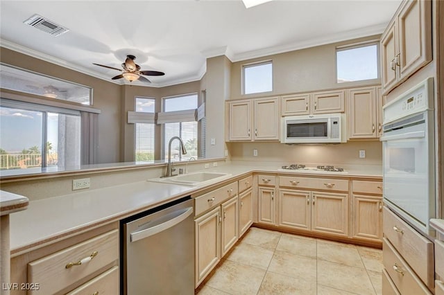 1904 Hot Oak Ridge St, Las Vegas, NV 89134 - kitchen with white appliances, light brown cabinets, light countertops, crown molding, and ceiling fan
