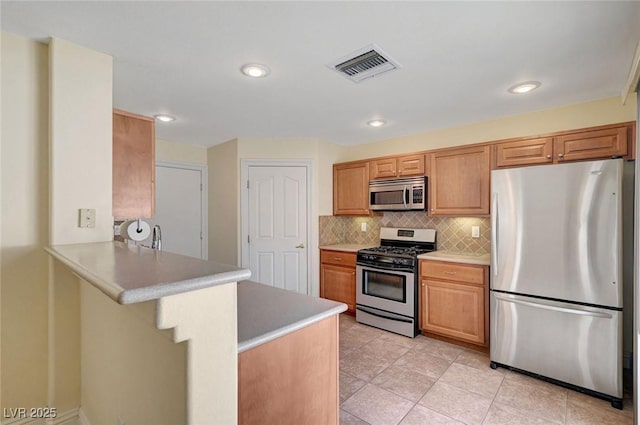 4841 Raw Umber Ct, Las Vegas, NV 89131 - kitchen with appliances with stainless steel finishes, tasteful backsplash, a peninsula, light countertops, and recessed lighting
