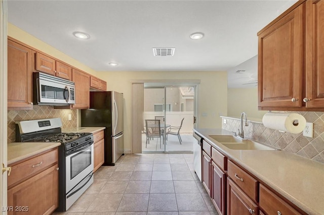 4841 Raw Umber Ct, Las Vegas, NV 89131 - kitchen featuring appliances with stainless steel finishes, tasteful backsplash, light countertops, recessed lighting, and brown cabinets