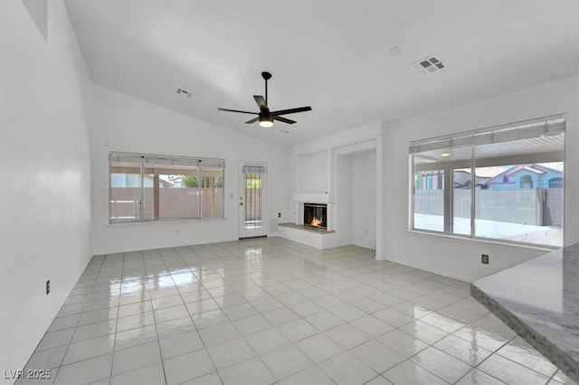 1613 Glenrosa Dr, North Las Vegas, NV 89031 - unfurnished living room with a ceiling fan, light tile patterned floors, vaulted ceiling, and a glass covered fireplace
