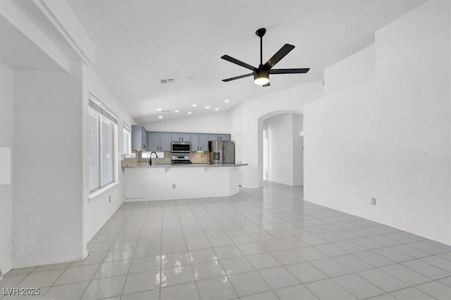 1613 Glenrosa Dr, North Las Vegas, NV 89031 - unfurnished living room with lofted ceiling, arched walkways, ceiling fan, recessed lighting, and light tile patterned floors