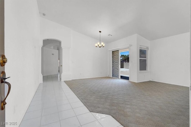 1613 Glenrosa Dr, North Las Vegas, NV 89031 - unfurnished living room with a chandelier, tile patterned flooring, arched walkways, carpet flooring, and vaulted ceiling