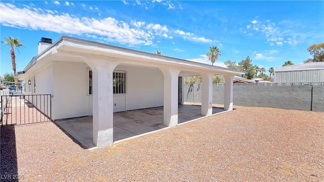 744 Hubbard St, Las Vegas, NV 89110 - view of side of home with a chimney, a patio area, and stucco siding