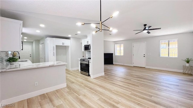 744 Hubbard St, Las Vegas, NV 89110 - kitchen featuring stainless steel appliances, open floor plan, a peninsula, white cabinetry, and a ceiling fan