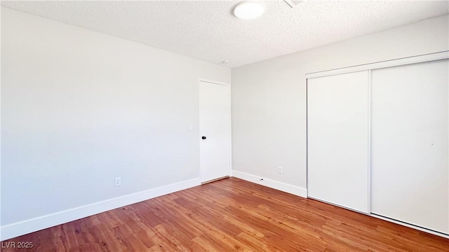 744 Hubbard St, Las Vegas, NV 89110 - unfurnished bedroom featuring wood finished floors, a closet, and a textured ceiling