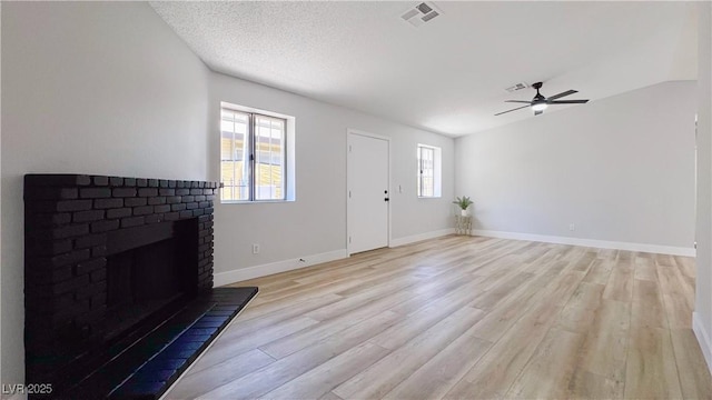 744 Hubbard St, Las Vegas, NV 89110 - unfurnished living room featuring light wood-style floors, a brick fireplace, and a ceiling fan
