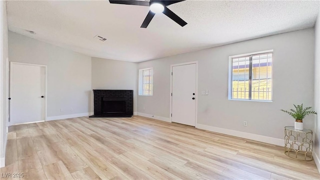 744 Hubbard St, Las Vegas, NV 89110 - unfurnished living room featuring healthy amount of natural light, light wood-style flooring, a brick fireplace, and a ceiling fan