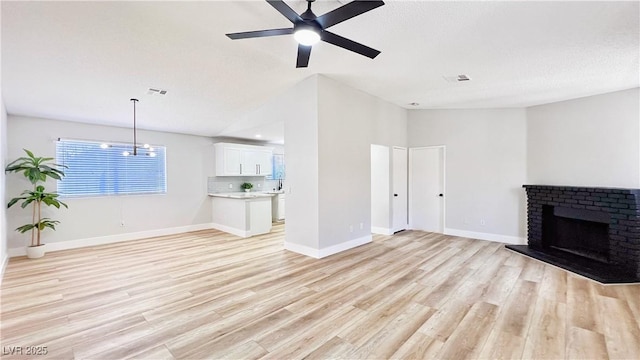 744 Hubbard St, Las Vegas, NV 89110 - unfurnished living room featuring light wood-type flooring, a ceiling fan, and a fireplace