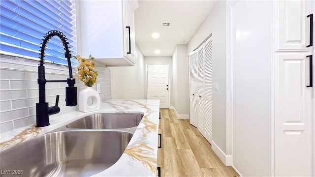744 Hubbard St, Las Vegas, NV 89110 - kitchen featuring light wood-style flooring, backsplash, white cabinetry, light stone counters, and recessed lighting