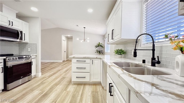 744 Hubbard St, Las Vegas, NV 89110 - kitchen featuring stainless steel appliances, backsplash, white cabinets, lofted ceiling, and a peninsula
