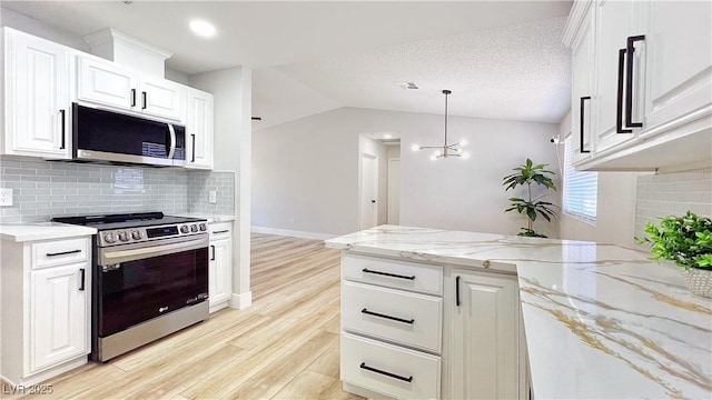 744 Hubbard St, Las Vegas, NV 89110 - kitchen with appliances with stainless steel finishes, light wood-style floors, backsplash, white cabinets, and lofted ceiling
