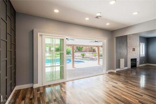 209 Camino Vista St, Henderson, NV 89012 - unfurnished living room featuring wood finished floors, plenty of natural light, recessed lighting, and a stone fireplace