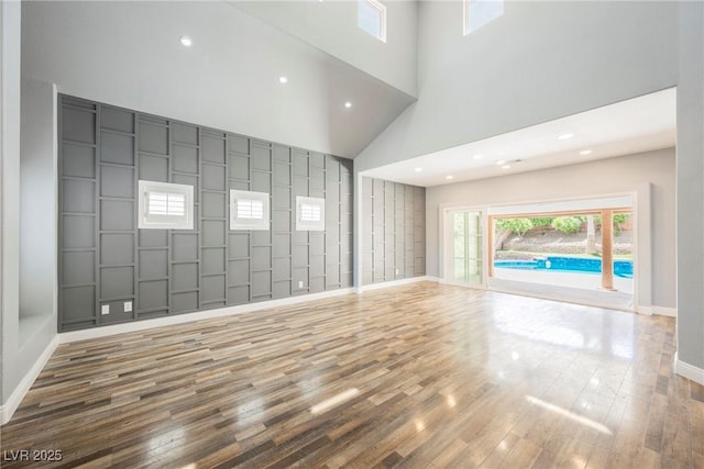 209 Camino Vista St, Henderson, NV 89012 - unfurnished living room featuring wood finished floors, a high ceiling, recessed lighting, and a package area