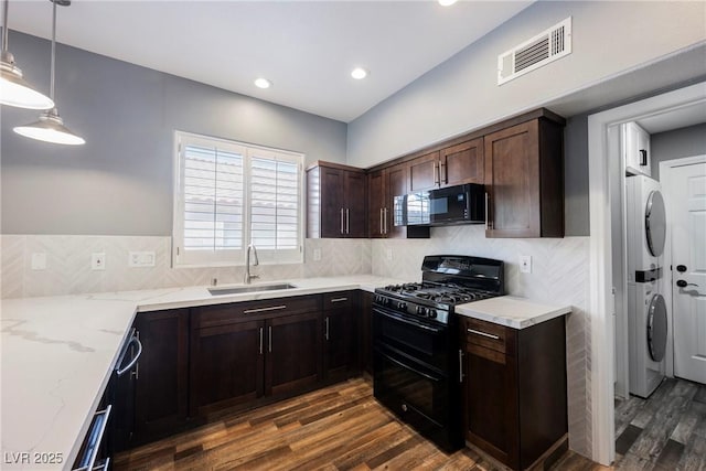 209 Camino Vista St, Henderson, NV 89012 - kitchen with black appliances, stacked washer and clothes dryer, light stone countertops, dark wood-style floors, and dark brown cabinetry